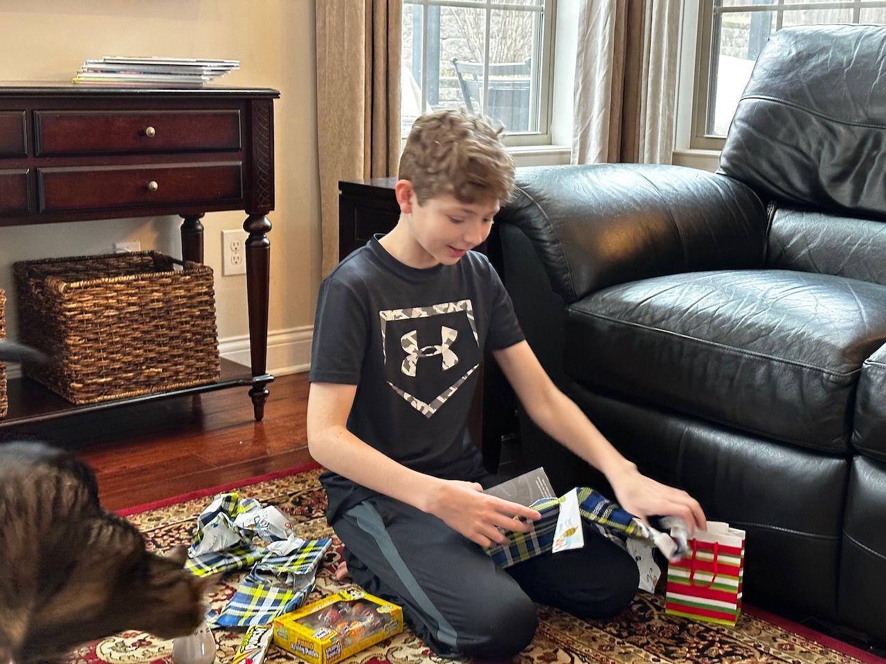 13 year old opening his birthday presents in the living room.
